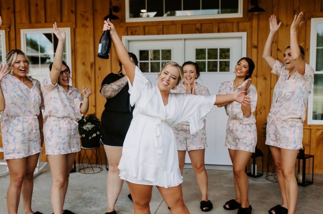 Bride and bridesmaids celebrating on the barn porch at Sunset Meadows